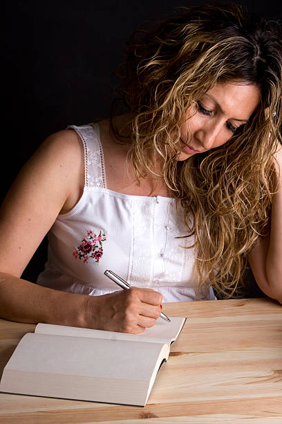 istock Mid-adult woman writing 183252108