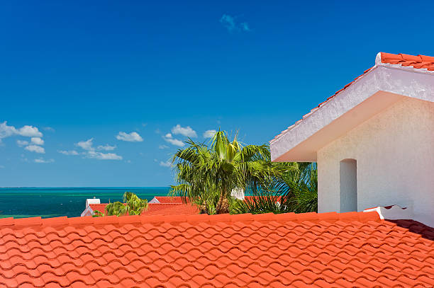 View of Isla Mujares and Tropical Clear Water.  Beautiful Carribean setting with white buildings with red tiles.  Aquamarine turquoise water with sailboat.  Captured as a 14-bit Raw file. Edited in ProPhoto RGB color space.