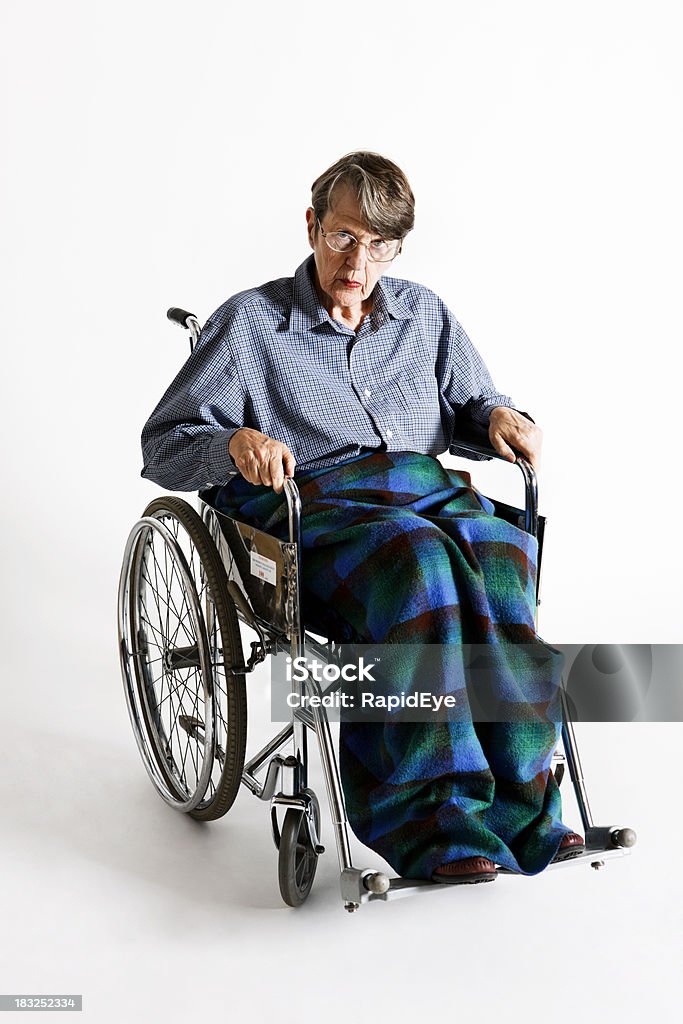 Arrabbiato vecchia donna in sedia a rotelle offre stimolanti look - Foto stock royalty-free di 60-69 anni
