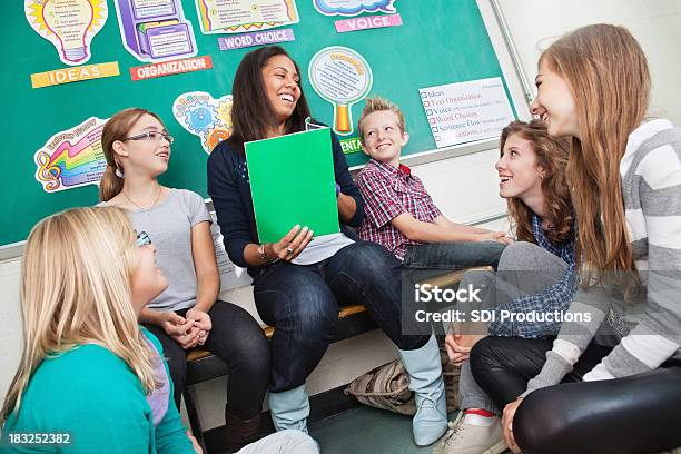 Teacher Reading To Students In Classroom Stock Photo - Download Image Now - Teacher, Laughing, Student