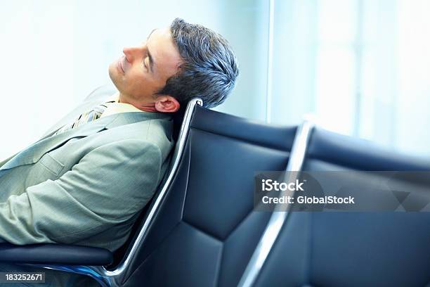 Zmęczony Średnim Wieku Człowiek Biznesu Opierając Się Na Chair At Airport - zdjęcia stockowe i więcej obrazów Administrator