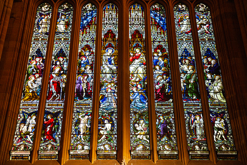 Medieval stained glass window depicting scenes from the life and martyrdom of Saint Stephen inside cathedral of York Minster in City of York, England, UK