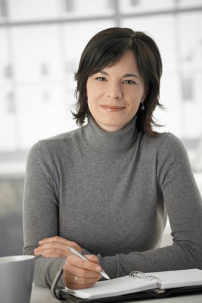 istock Young woman writing into personal organizer at home 183252762