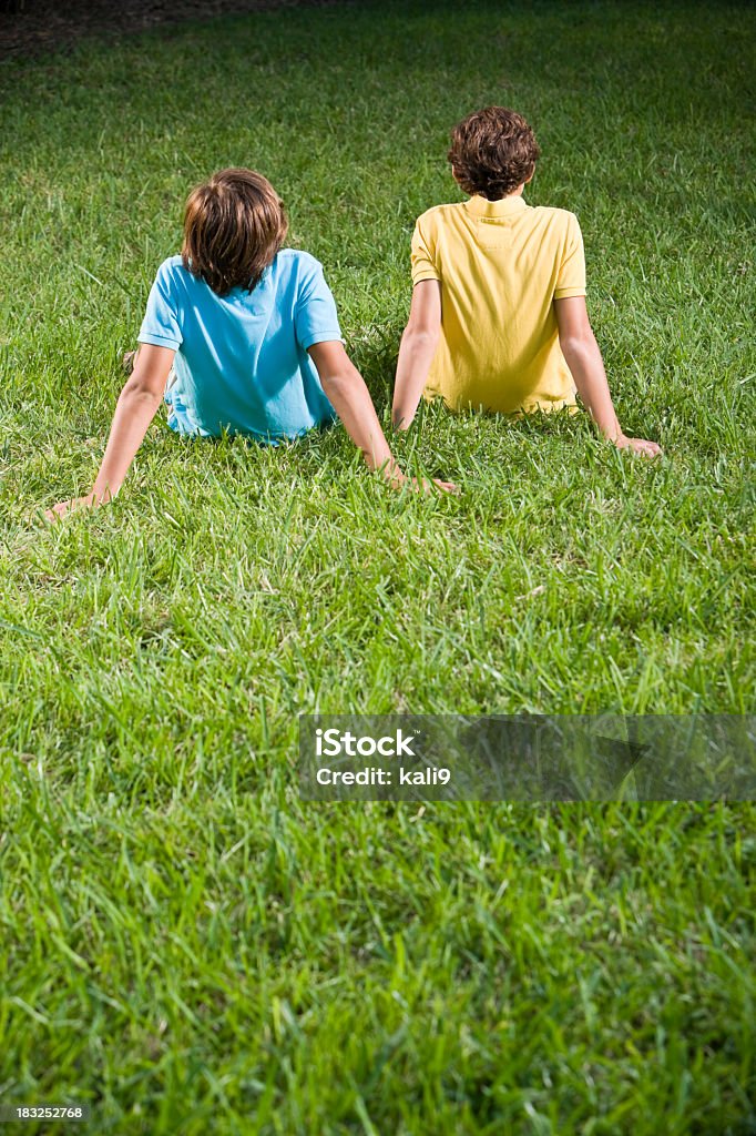 Retro di bambini seduti sull'erba - Foto stock royalty-free di 12-13 anni