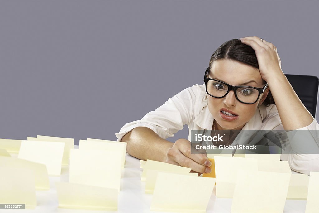 Stressé de jeune femme d'affaires avec des notes bloqué sur son bureau - Photo de Adulte libre de droits