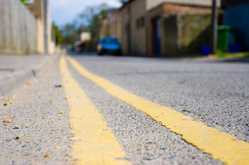 A perspective shot of double yellow lines along a roadside