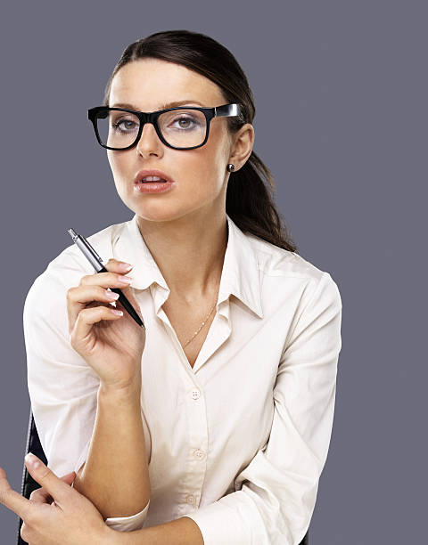 istock Young business woman holding pen against grey background 183253122
