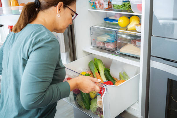 istock Woman opening refrigerator vegetables drawer 1832541617