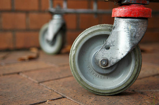 The rear wheels of a shopping cart.  Shallow depth of field.