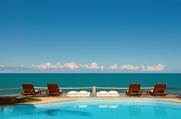 Swimming pool with spectacular view over the tropical ocean and a beautiful horizon. The perfect place for a vacation.