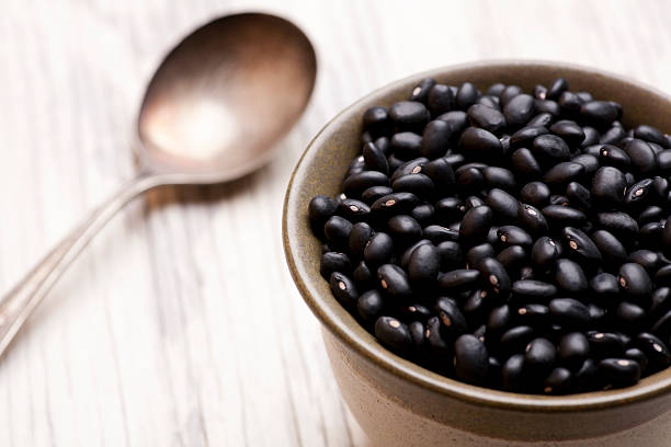 Bowl filled with a large amount of black beans stock photo