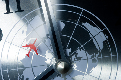 detail of a retro clock with timezones and plane.