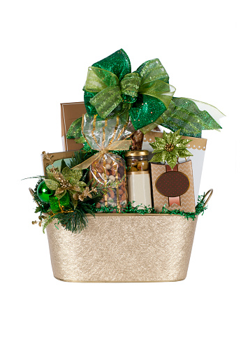 Gift basket in gold and green filled with a variety of nuts, chocolates, and other goodies.  Isolated on white.