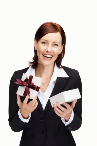 Portrait of a cheerful middle aged business woman holding a gift against white
