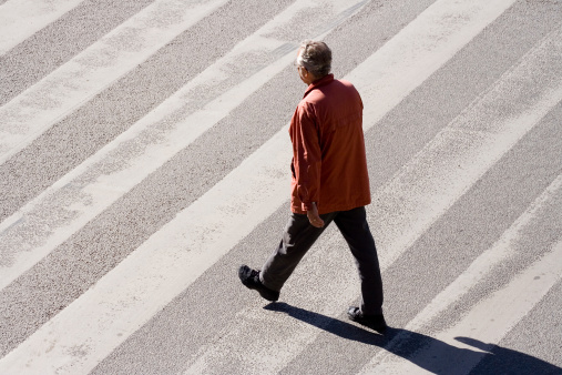 A man crossing the street alone.