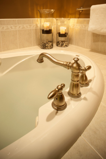 Luxurious hot tub soaking tub with romantic candles in a residential home interior.See more interior images: