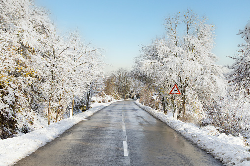 Country road during winter. Danger because of slippery street and due to wild animals crossing.