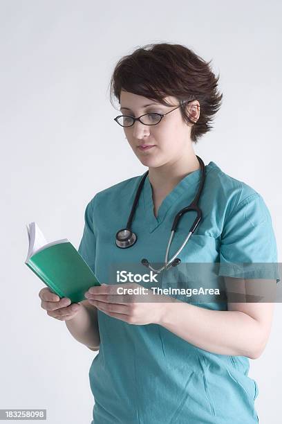 Nurse Reading Medical Reference Guide Stock Photo - Download Image Now - Accidents and Disasters, Coat - Garment, Concepts