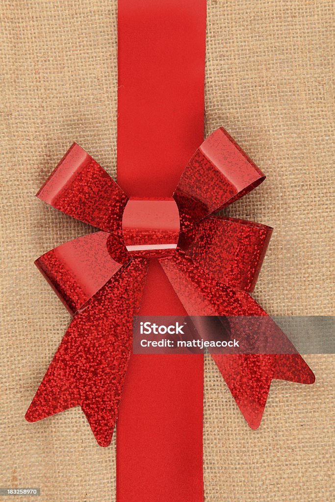 Laço de presente vermelho sobre fundo hessian - Foto de stock de Aniagem de Cânhamo royalty-free