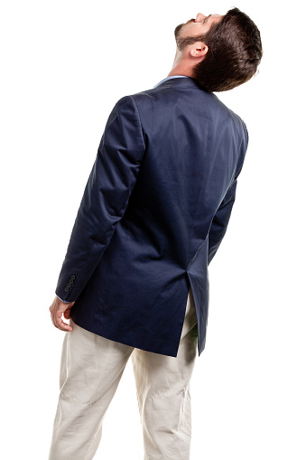 Rear view of a man wearing casual dark blue shirt black denim and white shoes, looking forward with hands on hips. Full body portrait isolated cut out