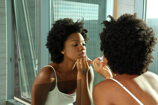 afro-americana mulher usando batom em um espelho - mirror women getting dressed clothing - fotografias e filmes do acervo