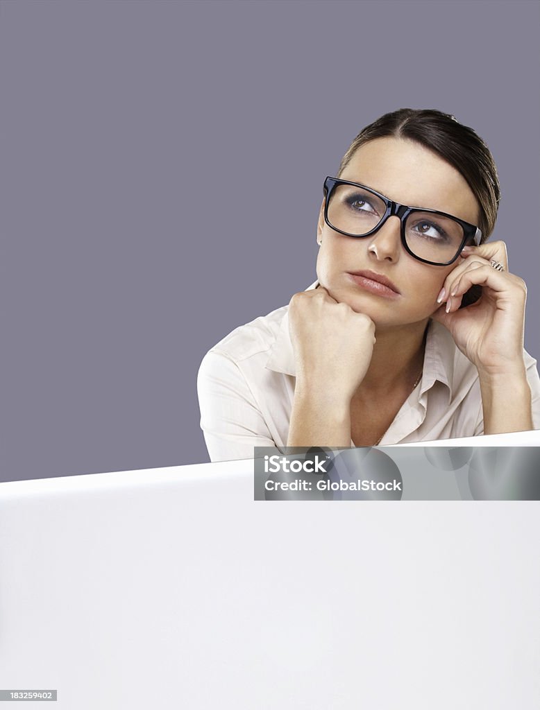 Pensive jeune femme d'affaires, portant des lunettes avec ordinateur portable - Photo de Affaires libre de droits