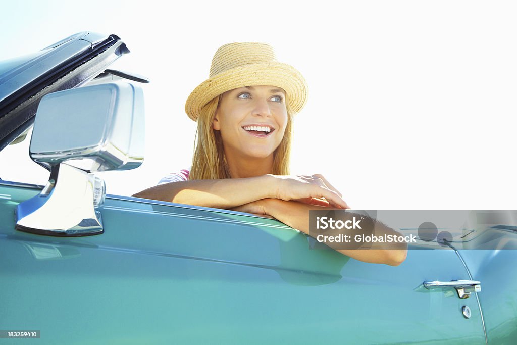 Sonriente mujer joven usando sombrero en un descapotable coche - Foto de stock de Coche libre de derechos