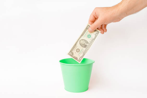 istock The dollar bill is thrown into the trash basket.White background,selective focus,copy space. 1832595053