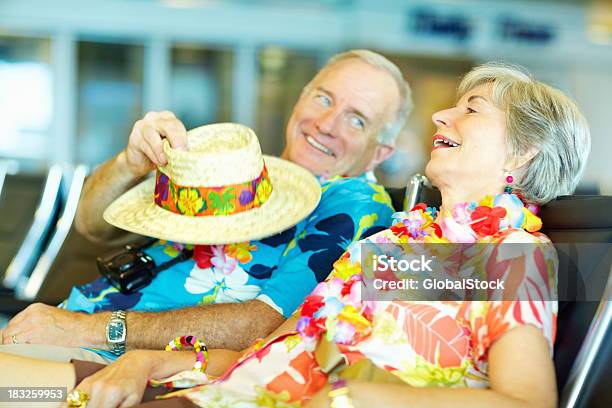 Foto de Casal Sênior Em Roupas De Flores Esperando Em Um Lounge De Aeroporto e mais fotos de stock de Aeroporto