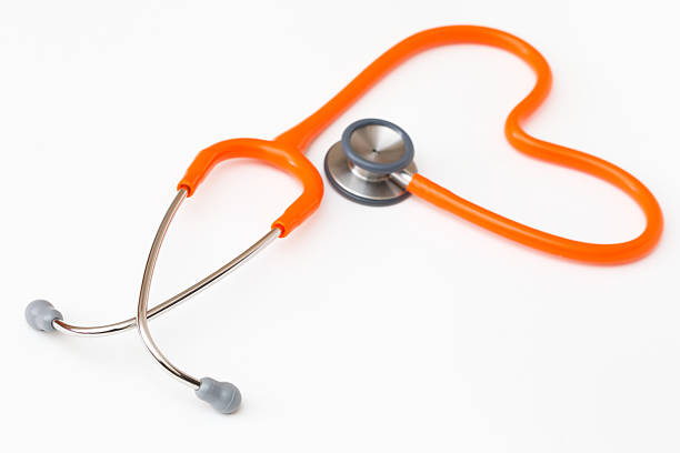 A orange stethoscope on a white background stock photo