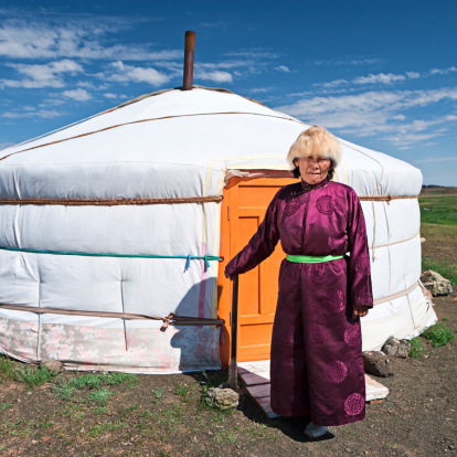 Mongolian woman in national clothing, ger (yurt) in the background.http://bem.2be.pl/IS/mongolia_380.jpg