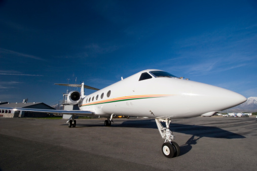 Gulfstream 4 fuselage, engine and wing with blue sky and wispy clouds.  