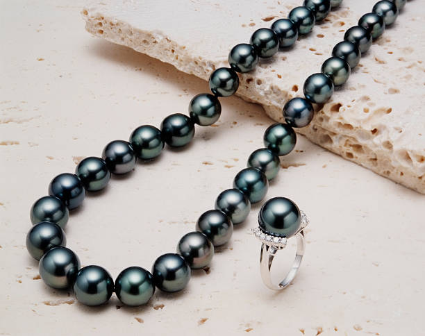 Black pearl necklace with ring on white stone