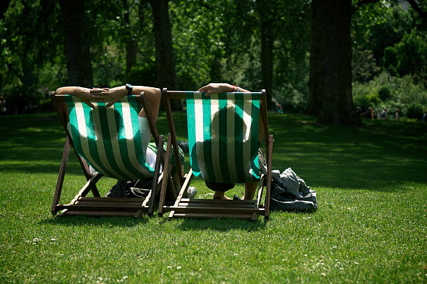 istock Two People Relaxing in Striped Deck Chairs London Park 183260952