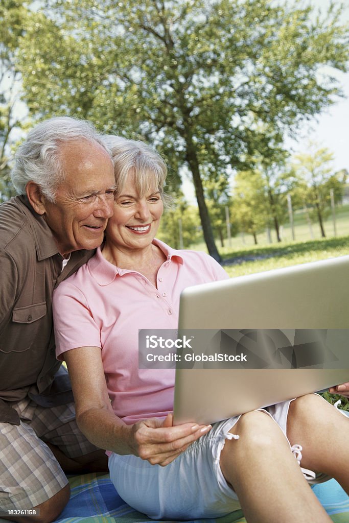 Sorridente Coppia senior lavorando con computer portatile - Foto stock royalty-free di Abbigliamento casual