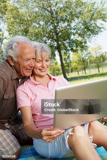 笑顔の年配のカップルがノートパソコンを使う - 50代のストックフォトや画像を多数ご用意 - 50代, よい知らせ, アクティブシニア