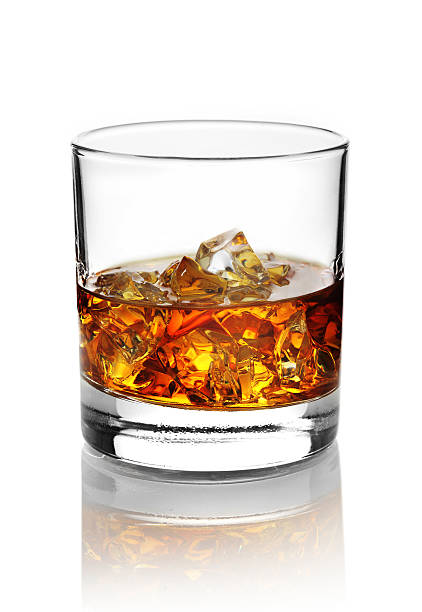 Glass with alcohol and ice cubes. Glass with whisky on the rocks isolated on white with reflection cognac region photos stock pictures, royalty-free photos & images