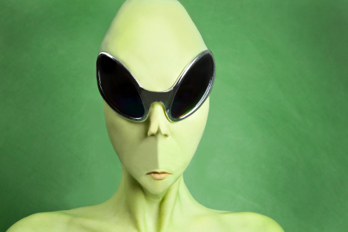 An alien portrait on a green background.