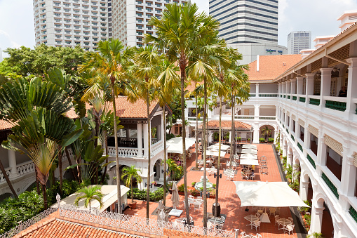 Singapore, Singapore - April 7 2012: A courtyard in Raffles Hotel, Singapore, South East Asia. Opened in 1899, it was named after Singapore's founder Sir Stamford Raffles. A colonial style hotel and a historic landmark.