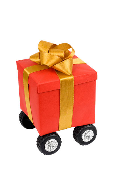 istock Red gift box with gold  ribbon on wheels 183261991