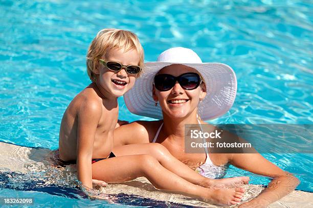 Foto de Sorrindo A Mãe E Crianças Com Óculos De Sol Na Piscina e mais fotos de stock de Adulto