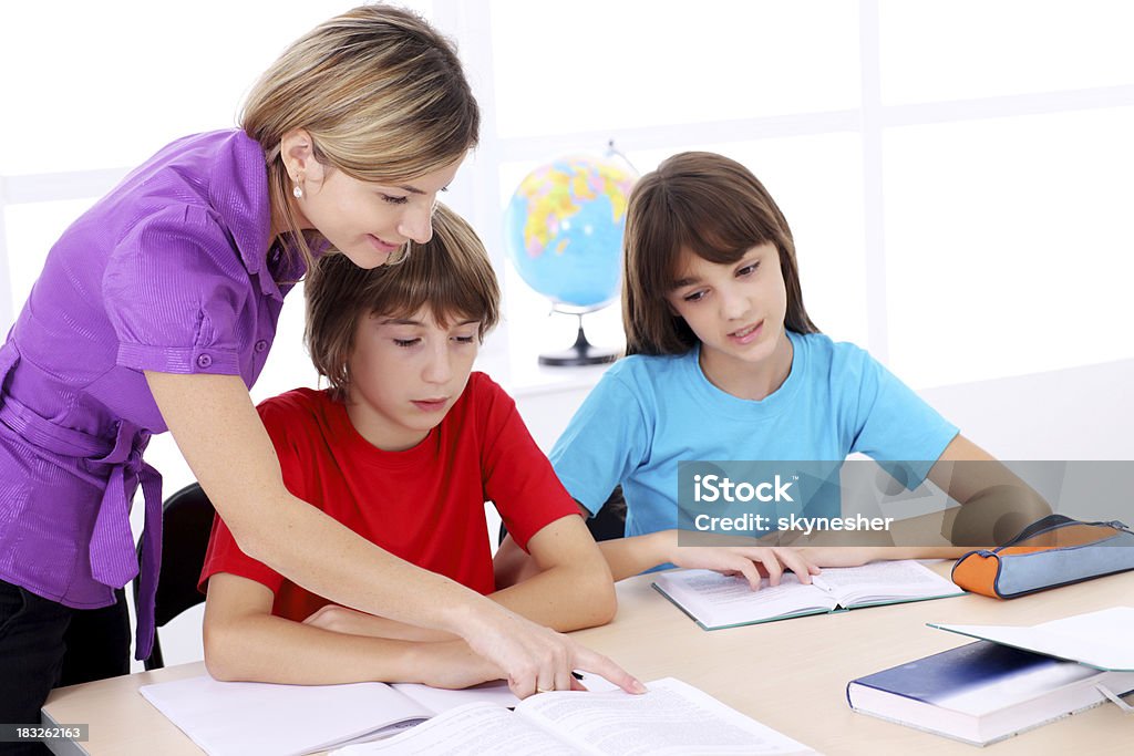 Schulkind-Lehrer erklären, die Aufgabe im Klassenzimmer. - Lizenzfrei Akademisches Lernen Stock-Foto