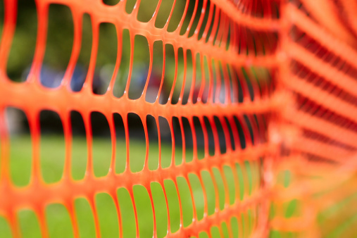 Low depth of field on a orange plastic fence.