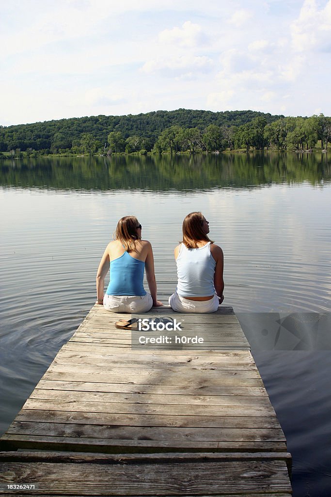 Filles sur le quai sur le lac - Photo de Jetée libre de droits