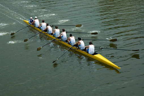 Group of men enjoying sailing on a summer day on calm sea. They are relaxing on mild sun at autumn