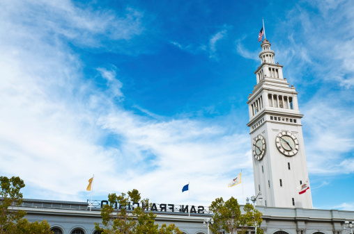 The iconic white clock tower of the 19th Century San Francisco Ferry Port building on The Embarcadero and Market Street. ProPhoto RGB profile for maximum color fidelity and gamut.