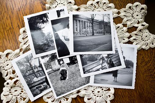 Collection of old vintage black and white photographs on a table showing the idea of nostalgia, time, memories and the past