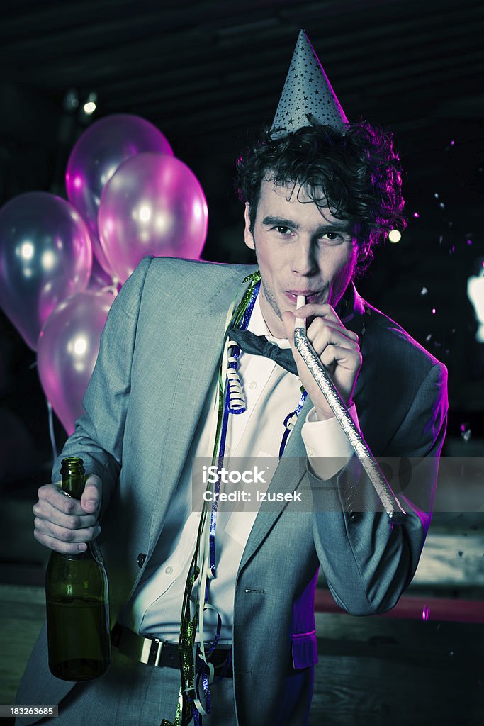 Young man celebrating New Year's Day "A well dressed handsome young man celebrating New Year's Day. Standing in front of balloons, looking at camera and smiling." Celebration Stock Photo