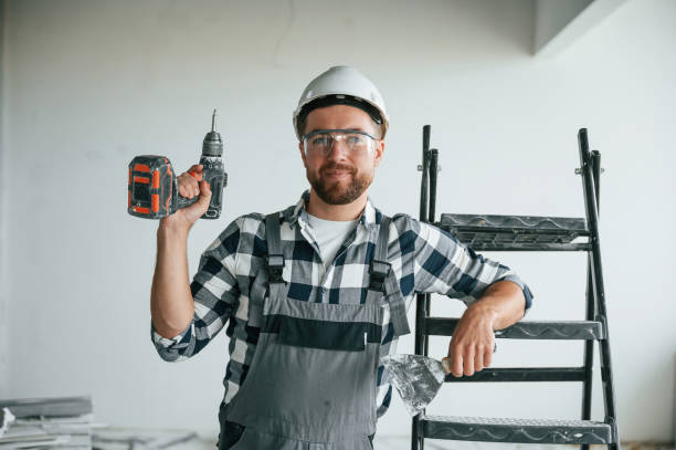 istock With drill. Repairman in uniform is in the unfinished building 1832639267