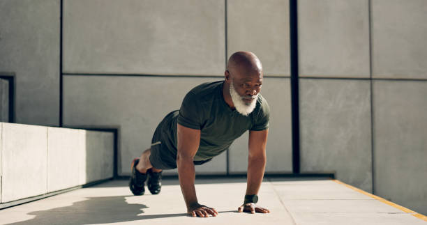 maturo, uomo e fitness per l'esercizio con pushup per la forza, la salute o il benessere dall'esterno. persona africana, sola e che si allena vicino alle scale per allenarsi con resistenza, concentrazione e dedizione - endurance sport foto e immagini stock